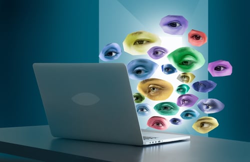 offener Laptop von hinten mit vielen bunten Augen, die auf das Display schauen