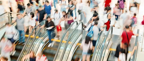 Menschen auf Rolltreppe im Shopping Center