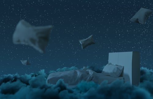 nachtblauer Himmel und leerem Bett und schwebenden Kissen im Vordergrund